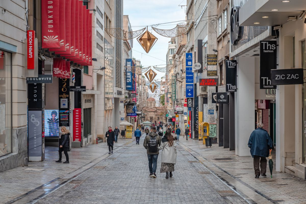  Incidental people on Ermou st, with the Byzantine Church of Panaghia Kapnikarea in the background.